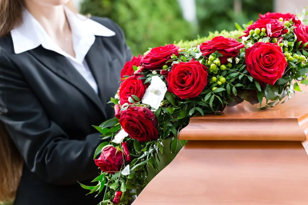 Composition florale de rose rouge et blanche sur un cercueil